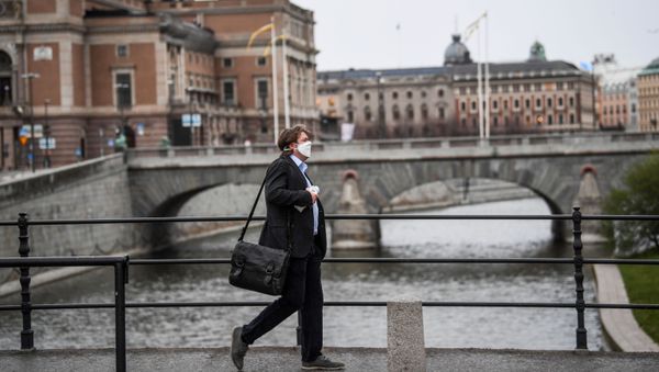 A man wearing a protective mask walks past the Royal Swedish Opera, amid the coronavirus disease (COVID-19) outbreak in Stockholm, Sweden, April 27, 2020 - Sputnik International