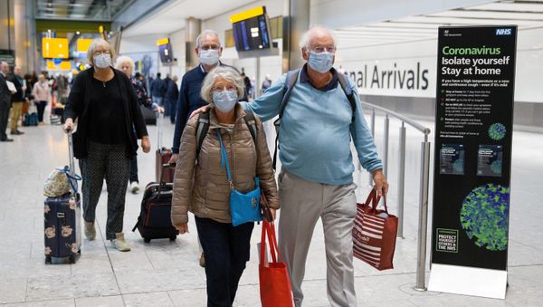Travellers who had been aboard the Braemar cruise ship, operated by Fred Olsen Cruise Lines, and wearing face masks as a precautionary measure against covid-19, react as they arrive at Heathrow Airport in London on March 19, 2020, after being flown back from Cuba. - Sputnik International