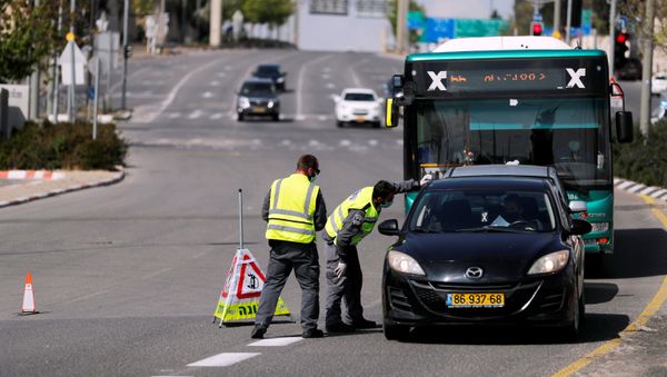 Israeli police check a driver in a car on a roadblock in a main road in Jerusalem as they try to contain the spread of the coronavirus  disease (COVID-19) from the densely populated neighborhoods where the infection rate is high, April 12, 2020. - Sputnik International