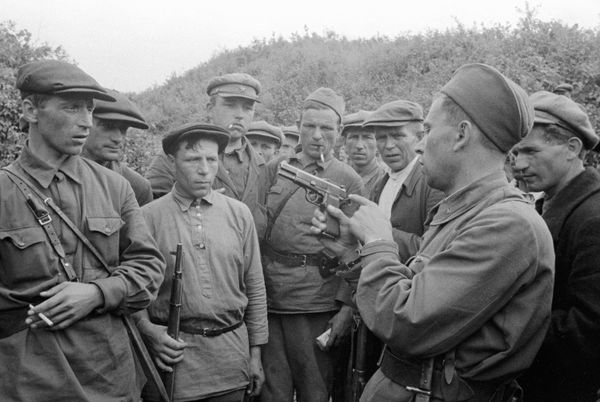 The commander of a partisan detachment shows weapons to fighters. Smolensk region, the USSR, 1941 The commander of a partisan detachment shows weapons to fighters. Smolensk region, the USSR, 1941 - Sputnik International