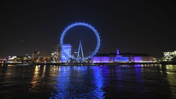 The London Eye lit up with blue light in support of British National Health Service workers who are treating coronavirus victims, as part of a nationwide salute to the doctors, nurses and staff of the NHS in London, Thursday, March 26, 2020 - Sputnik International