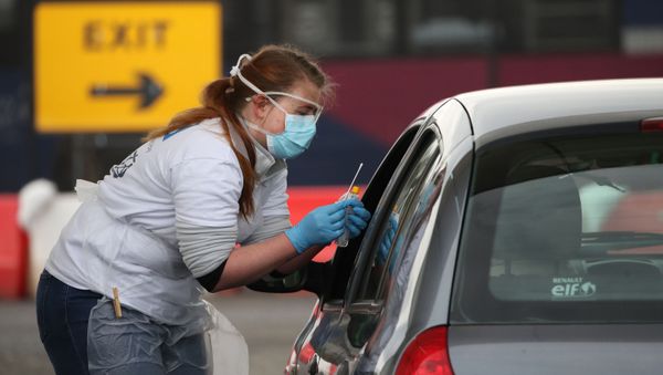 A medical worker tests a key worker for the novel coronavirus Covid-19 at a drive-in testing centre at Glasgow Airport on April 29, 2020, as the UK continues in lockdown to help curb the spread of the coronavirus. A medical worker tests a key worker for the novel coronavirus Covid-19 at a drive-in testing centre at Glasgow Airport on April 29, 2020, as the UK continues in lockdown to help curb the spread of the coronavirus. - Sputnik International
