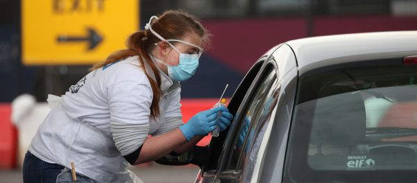 A medical worker tests a key worker for the novel coronavirus Covid-19 at a drive-in testing centre at Glasgow Airport on April 29, 2020, as the UK continues in lockdown to help curb the spread of the coronavirus. - Sputnik International