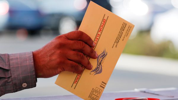 An election worker places a mail-in ballot into an election box at a drive-through drop off location at the Registrar of Voters in San Diego, California, US, 5 November 2018 - Sputnik International
