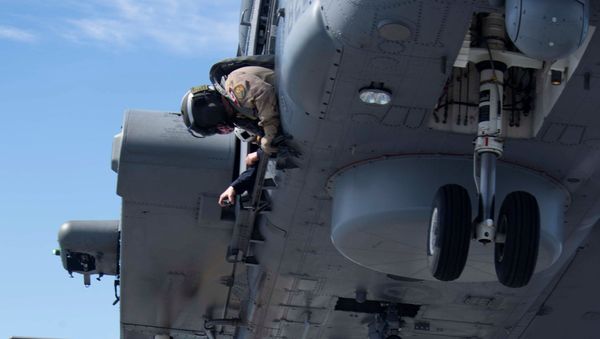 Master Corporal Chad Amirault (L) and Corporal Dominik Angelini hook a load to a CH-148 Cyclone helicopter aboard HMCS Fredericton during Operation Reassurance at sea March 14, 2020, in this picture obtained from social media. Picture taken March 14, 2020.  - Sputnik International