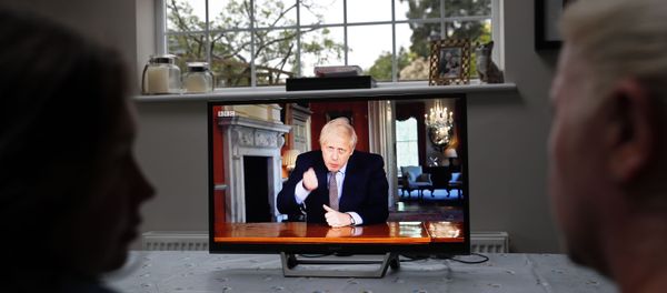 A family gather around the television to watch Britain's Prime Minister Boris Johnson give a televised message to the nation in Hartley Wintney, west of London on May 10, 2020, as the government sets out it's roadmap to ease the national lockdown due to the novel coronavirus COVID-19 pandemic. - Sputnik International