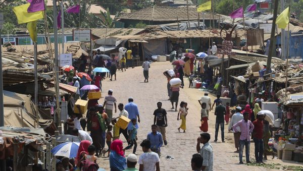 Rohingya refugees, without wearing any mask or any other safty gear as a preventive measure against the COVID-19 novel coronavirus, gather along a market area in Kutupalong refugee camp in Ukhia  24 March 2020.  - Sputnik International