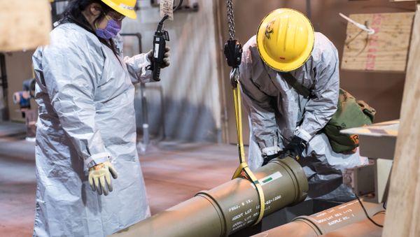 Two operators work together to place one of the last overpacked 8-inch projectiles containing nerve agent into a tray to begin the destruction process at the Blue Grass Chemical Agent-Destruction Pilot Plant May 9. The last GB 8-inch projectile was destroyed May 11, marking the complete destruction of an entire type of chemical weapon. - Sputnik International
