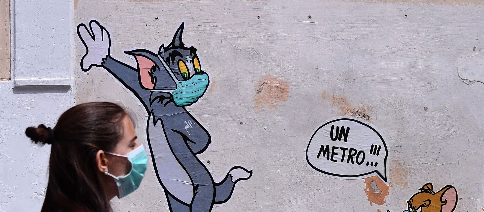A woman wearing a face mask passes by a mural featuring William Hanna and Joseph Barbera' s characters Tom & Jerry mentioning the safe distance to be held from each other - One meter - in Rome, Friday, May 15, 2020 A woman wearing a face mask passes by a mural featuring William Hanna and Joseph Barbera' s characters Tom & Jerry mentioning the safe distance to be held from each other - One meter - in Rome, Friday, May 15, 2020 - Sputnik International, 1920
