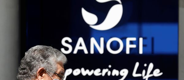 A man wearing a protective face mask walks past the logo of Sanofi at the company's headquarters in Paris, France, April 24, 2020. R - Sputnik International