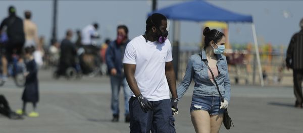 Pedestrians wear protective masks during the coronavirus pandemic while walking on the boardwalk of Coney Island Beach Friday, May 15, 2020, in the Brookyn borough of New York Pedestrians wear protective masks during the coronavirus pandemic while walking on the boardwalk of Coney Island Beach Friday, May 15, 2020, in the Brookyn borough of New York - Sputnik International