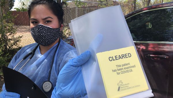 Certified Medical Assistant Shaniya Wood displays a certification card that homeless residents can use to show they are free of the coronavirus to gain access to shelters and other services, Thursday, May 7, 2020 in Gallup, N.M. More than 100 homeless people in Gallup are being housed temporarily in motel rooms and tested for the coronavirus to contain an outbreak that raced through a detox center in early April. Gallup was under a lockdown order with police roadblocks from New Mexico Gov. Michelle Lujan Grisham in efforts to stem the rapid transmission of COVID-19 in the area. Gallup and surrounding McKinley County are one of the worst rural hot spots for the coronavirus infections in the U.S. (AP Photo/Morgan Lee) - Sputnik International