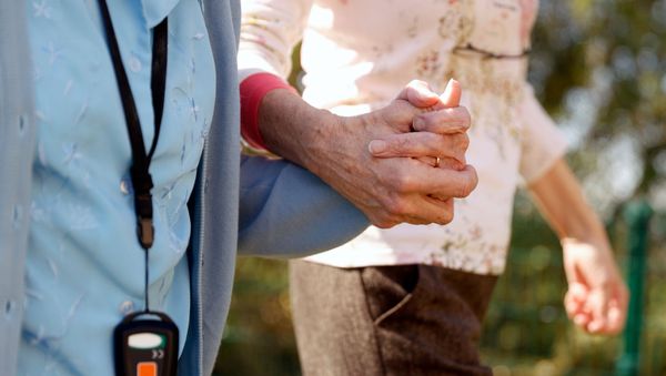 Resident Enid Roche takes a walk in the grounds of Foxholes Care Home, assisted by activities director Susan Davies as the spread of the coronavirus disease (COVID-19) continues, Hitchin, Britain, 25 March 2020. - Sputnik International