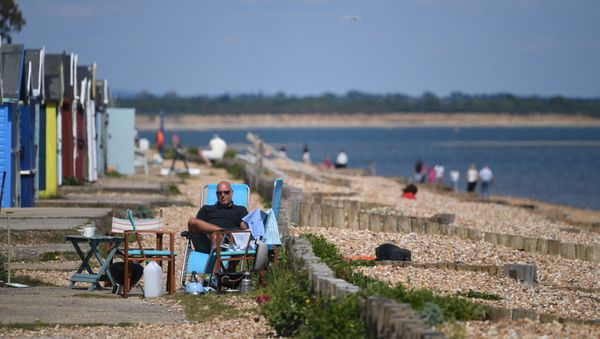 Мужчина во время отдыха на пляже в Южной Англии  - Sputnik International