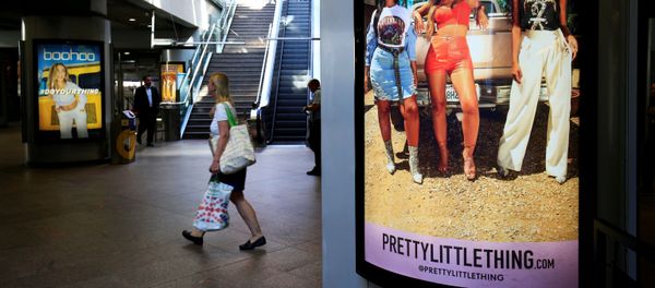  A shopper walks past an advertising billboards for Boohoo and for 'Pretty Little Things', a Boohoo brand, at Canary Wharf DLR station in central London, Britain, 17 September 2018 - Sputnik International
