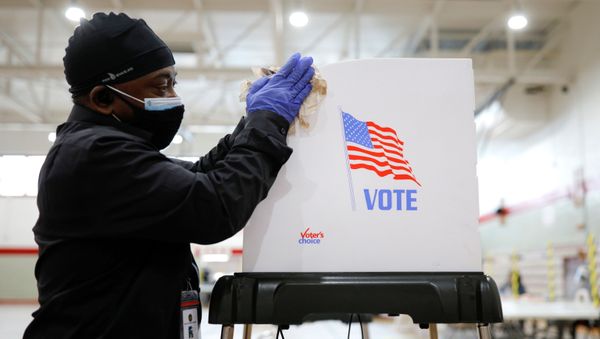 Kyle Henry, a volunteer poll site worker at the Edmondson Westside High School Polling site, sanitizes a write-in ballot station after it was used during the special election for Marylands 7th congressional district seat, previously held by Rep. Elijah Cummings (D-MD), in Baltimore, Maryland, U.S., April 28, 2020. - Sputnik International