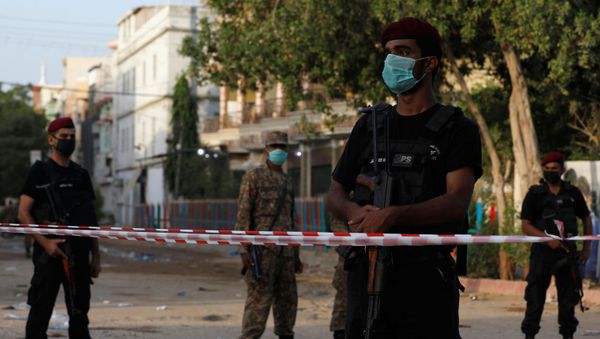 Police officers guard a cordoned-off street leading to the site of a passenger plane crash in a residential area near an airport in Karachi, Pakistan May 23, 2020 - Sputnik International