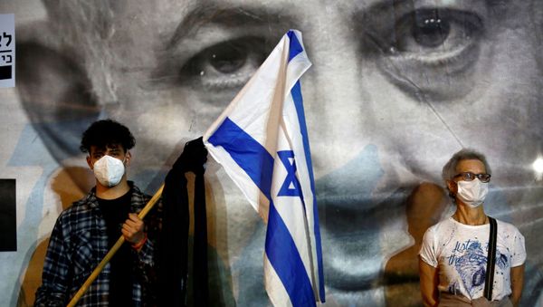 A man wearing a protective face mask holds an Israel's flag A man wearing a protective face mask holds an Israel's flag - Sputnik International