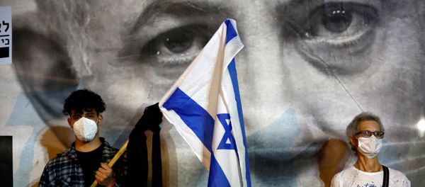 A man wearing a protective face mask holds an Israel's flag A man wearing a protective face mask holds an Israel's flag - Sputnik International