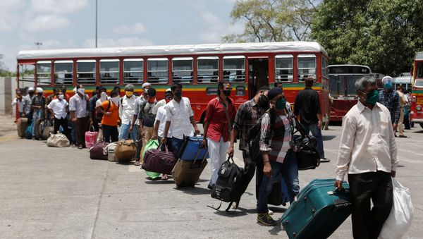 Migrants carrying luggage arrive at a railway station to board a train to their home state of Uttar Pradesh during an extended lockdown to slow the spread of the coronavirus - Sputnik International