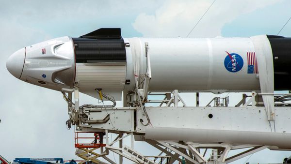 Crews work on the SpaceX Crew Dragon, attached to a Falcon 9 booster rocket, as it sits horizontal on Pad39A at the Kennedy Space Center in Cape Canaveral, Florida, U.S. May 26, 2020. - Sputnik International