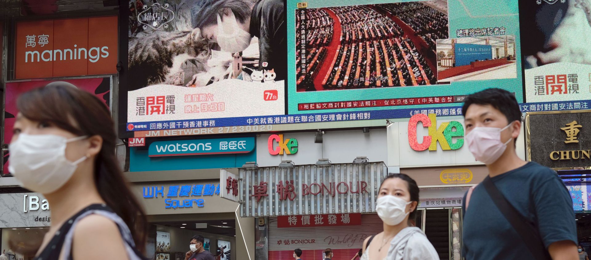 People walk past a TV screen showing the closing session of the National People's Congress (NPC) in Beijing where voting on the national security legislation for Hong Kong took place, in Hong Kong, China May 28, 2020. - Sputnik International, 1920, 18.06.2020