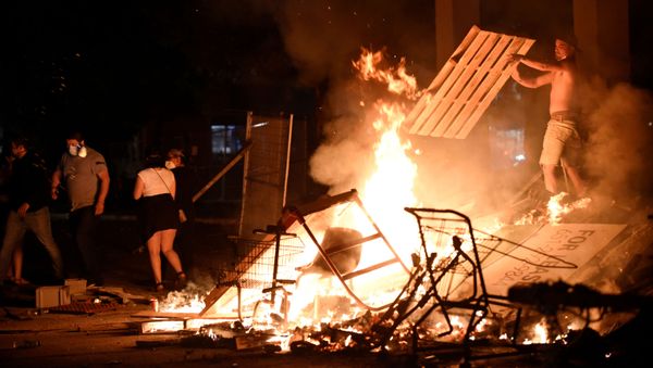 A protester adds wood to a fire barricade on 26th Ave S near the Minneapolis Police third precinct after a white police officer was caught on a bystander's video pressing his knee into the neck of African-American man George Floyd, who later died at a hospital, in Minneapolis, Minnesota, U.S. May 27, 2020. Picture taken May 27, 2020 A protester adds wood to a fire barricade on 26th Ave S near the Minneapolis Police third precinct after a white police officer was caught on a bystander's video pressing his knee into the neck of African-American man George Floyd, who later died at a hospital, in Minneapolis, Minnesota, U.S. May 27, 2020. Picture taken May 27, 2020 - Sputnik International