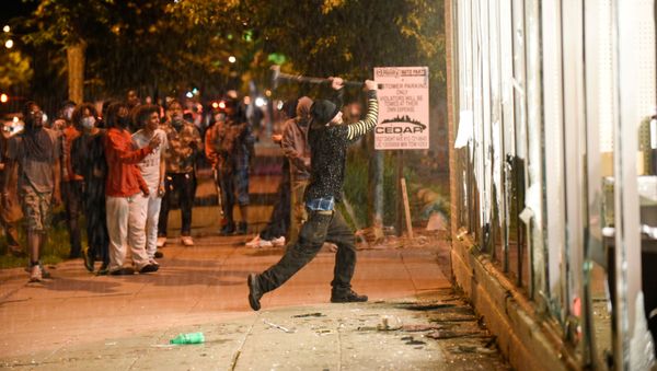 A protester vandalizes an O'Reilly's near the Minneapolis Police third precinct, where demonstrators gathered after a white police officer was caught on a bystander's video pressing his knee into the neck of African-American man George Floyd, who later died at a hospital, in Minneapolis, Minnesota, U.S. May 27, 2020. - Sputnik International