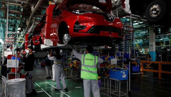  Employees, wearing protective face masks, work on the automobile assembly line of Renault ZOE cars with sign on the floor to maintain social distancing at the Renault automobile factory in Flins as the French carmaker ramps up car production with new security and health measures during the outbreak of the coronavirus disease (COVID-19) in France, May 6, 2020 - Sputnik International