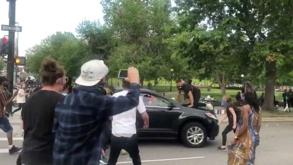 A protester is seen on top of a vehicle speeding through a protest held nationally, following the death of African-American George Floyd who was seen in graphic video footage gasping for breath as a white officer knelt on his neck, in Minneapolis, Minnesota, in Denver, Colorado, May 28, 2020 - Sputnik International