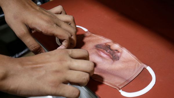 A man prepares a face mask with the photograph of a customer printed on it, amid the spread of the coronavirus disease (COVID-19), at a photo studio in Gandhinagar, India, May 27, 2020.  - Sputnik International