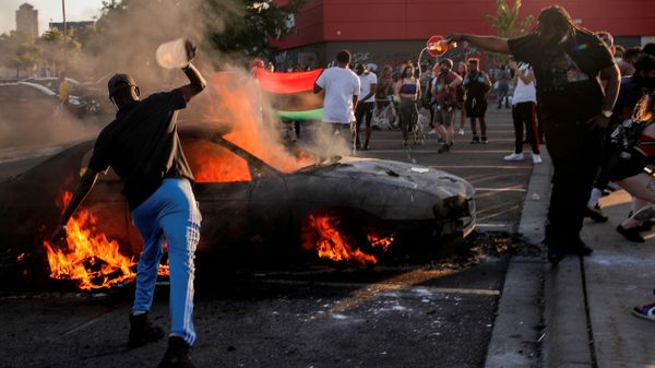 People react as a car burns at the parking lot of a Target store during protests after a white police officer was caught on a bystander's video pressing his knee into the neck of African-American man George Floyd, who later died at a hospital, in Minneapolis, Minnesota, U.S., May 28, 2020 People react as a car burns at the parking lot of a Target store during protests after a white police officer was caught on a bystander's video pressing his knee into the neck of African-American man George Floyd, who later died at a hospital, in Minneapolis, Minnesota, U.S., May 28, 2020 - Sputnik International