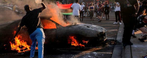 People react as a car burns at the parking lot of a Target store during protests after a white police officer was caught on a bystander's video pressing his knee into the neck of African-American man George Floyd, who later died at a hospital, in Minneapolis, Minnesota, U.S., May 28, 2020 People react as a car burns at the parking lot of a Target store during protests after a white police officer was caught on a bystander's video pressing his knee into the neck of African-American man George Floyd, who later died at a hospital, in Minneapolis, Minnesota, U.S., May 28, 2020 - Sputnik International