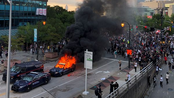 An Atlanta Police car burns as people protest against the death in Minneapolis police custody of African-American man George Floyd, near CNN Center in Atlanta, Georgia, U.S. May 29, 2020. - Sputnik International