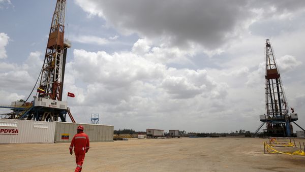 An oilfield worker walks next to drilling rigs at an oil well operated by Venezuela's state oil company PDVSA, in the oil rich Orinoco belt, near Morichal at the state of Monagas April 16, 2015. - Sputnik International