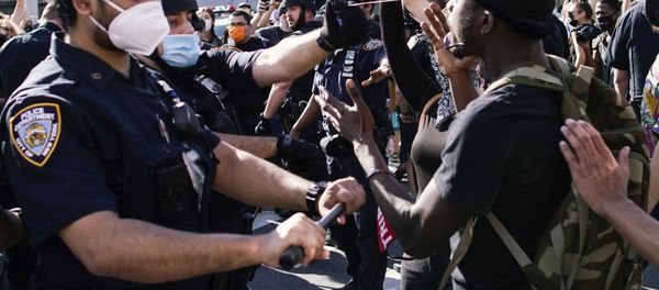 A NYPD police officer sprays protesters as they clash during a march against the death in Minneapolis police custody of George Floyd, in the Brooklyn borough of New York City, U.S., May 30, 2020. - Sputnik International
