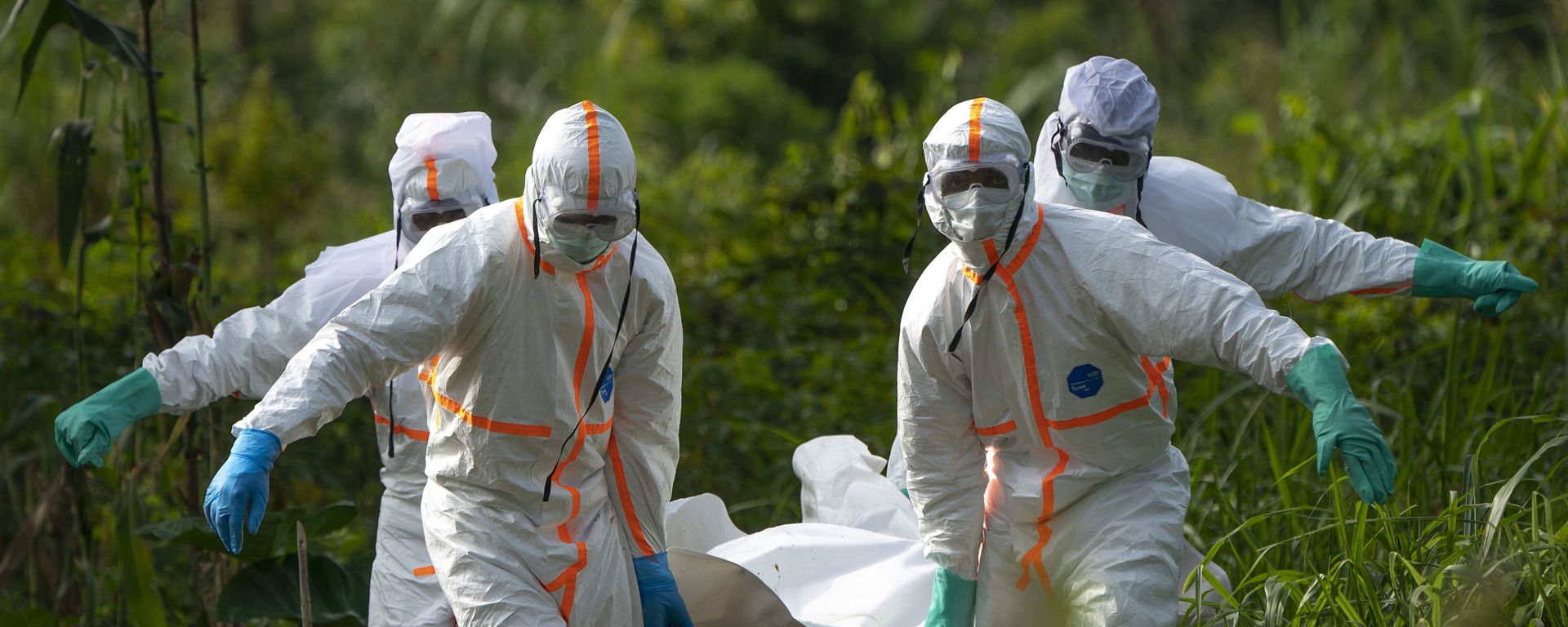 In this Sunday, July 14, 2019 photo, burial workers dressed in protective gear carry the remains of Mussa Kathembo, an Islamic scholar who had prayed over those who were sick, in Beni, Congo - Sputnik International, 1920, 14.02.2021