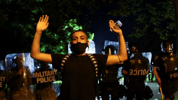 A demonstrator raises his hands as police officers and Washington, DC National Guard military police officers stand guard during a protest against the death in Minneapolis police custody of George Floyd, near the White House, in Washington, U.S., May 30, 2020 A demonstrator raises his hands as police officers and Washington, DC National Guard military police officers stand guard during a protest against the death in Minneapolis police custody of George Floyd, near the White House, in Washington, U.S., May 30, 2020 - Sputnik International