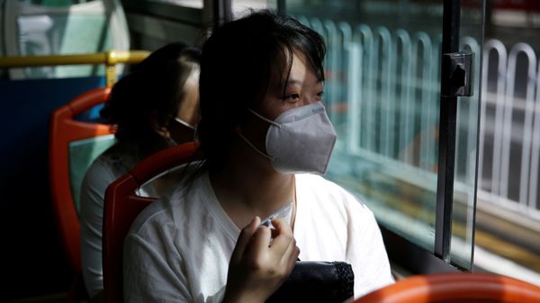 Woman wearing a face mask rides on a bus with her husband and friends to a shopping mall to look for a job in Beijing - Sputnik International