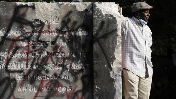 Robert Walker poses for a photograph on the remains of a Confederate memorial that was removed overnight in Birmingham, Ala., on Tuesday, June 2, 2020 - Sputnik International