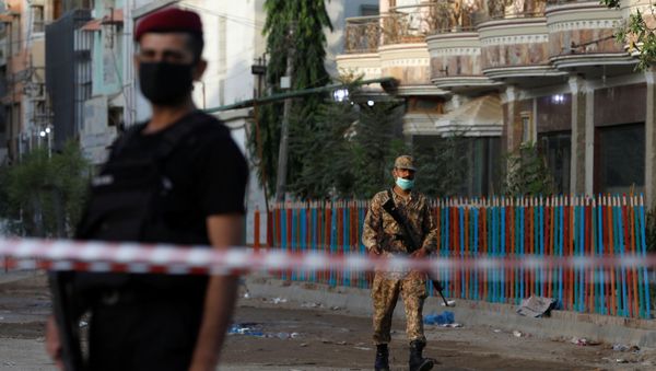 Army soldier walks along a cordoned-off street leading to the site of a passenger plane crash in a residential area near an airport in Karachi, Pakistan May 23, 2020. - Sputnik International