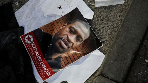 A portrait of George Floyd, who died in police custody in  Minneapolis, U.S., lies on the ground next to a protective face mask after a scuffle took place during a protest in Istanbul, Turkey, June 2, 2020 - Sputnik International