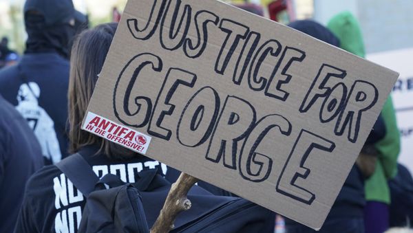 A poster with the inscription 'Justice for George' and 'Antifa on the offensive' is held by a protestor during a demonstration under the motto Youth Day - Fight for your future - Sputnik International