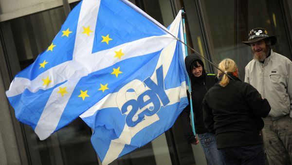 This picture shows pro-independence campaigners with one holding a 'yes' to independence flag and another holding a Saltire flag with EU logo design, outside the Scottish Parliament b - Sputnik International