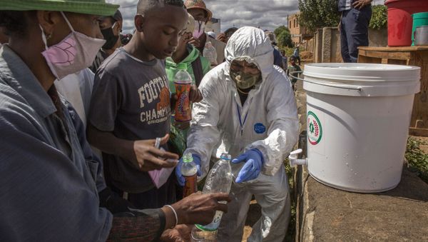 In this photo taken Friday, April 24, 2020 residents are given bottles of a herbal mixture which is said to prevent and cure COVID-19 in Antanarivo, Madagascar. President Andry Rajoelina is promoting the drink but there is no scientific proof to back up his claims. - Sputnik International