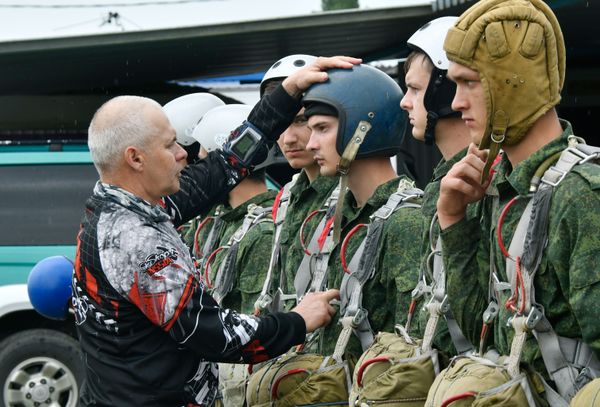 A coach is checking a recruit's equipment before his first jump at the Enem airfield A coach is checking a recruit's equipment before his first jump at the Enem airfield - Sputnik International