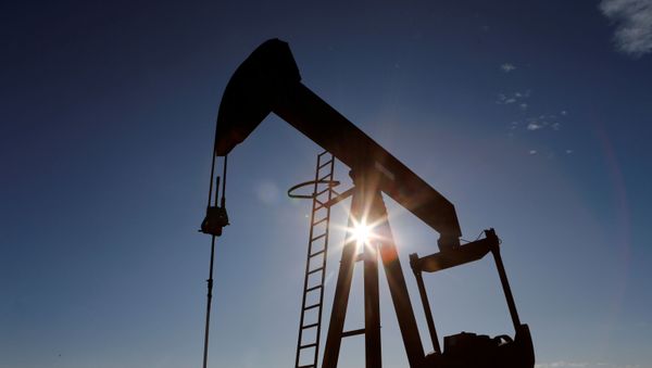 The sun is seen behind a crude oil pump jack in the Permian Basin in Loving County, Texas, U.S., November 22, 2019. Picture taken November 22, 2019 - Sputnik International