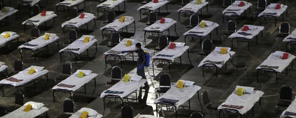 A civic worker sprays disinfectant on beds at a special temporary hospital facility for COVID-19 patients in Mumbai, India, Friday, April 10, 2020 - Sputnik International
