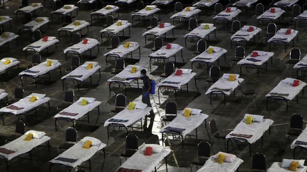 A civic worker sprays disinfectant on beds at a special temporary hospital facility for COVID-19 patients in Mumbai, India, Friday, April 10, 2020 - Sputnik International