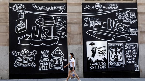 A woman wearing a protective face mask walks past graffiti on boarded up and closed storefronts in the Soho neighborhood of Manhattan during the outbreak of the coronavirus disease (COVID-19) in New York City, New York, U.S., May 26, 2020. - Sputnik International